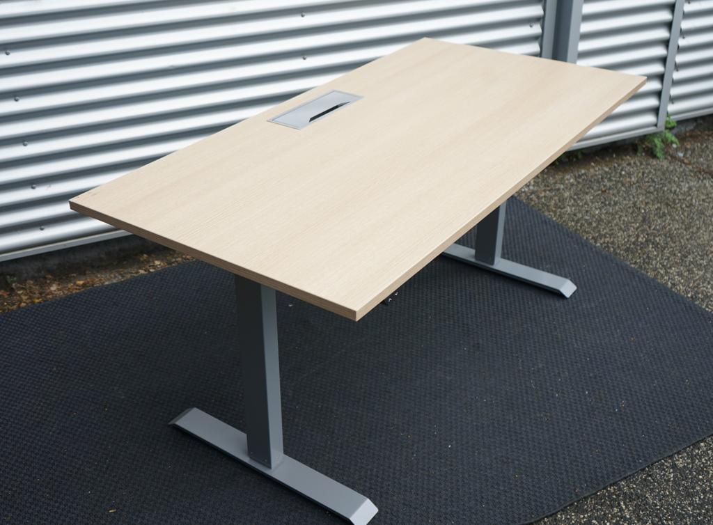 Conset hæve-sænkebord 160x80 i egetræ farve set fra siden med elegant design og elektrisk højdejustering.